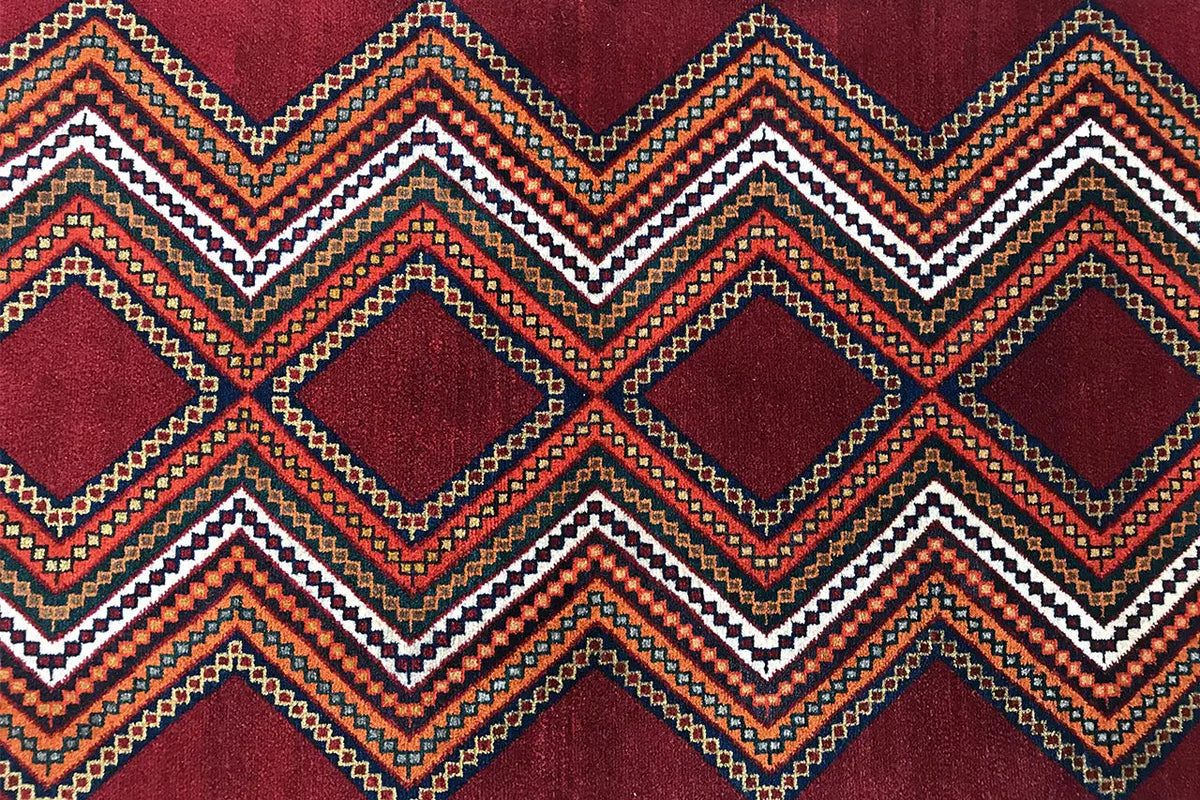 Gabbeh rug detail: reddish-brown area with zigzag and diamond patterns