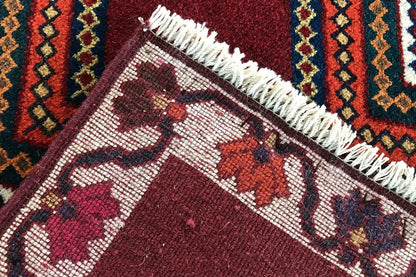 Gabbeh rug edge detail with fringes, dark red surface with ornaments