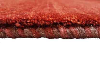 Close-up of the edge of the carpet: dense red pile with underside and edge