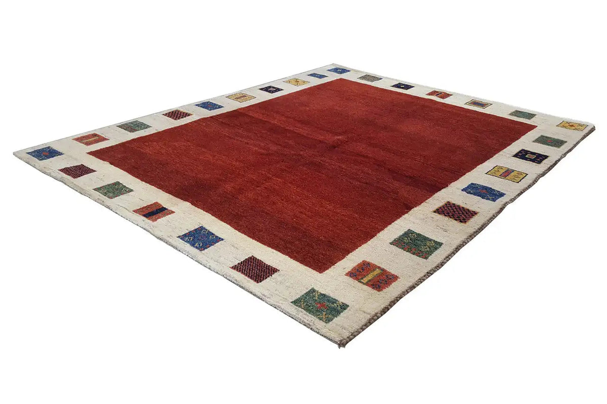 Gabbeh rug, 190x156 cm: red field with a beige border of small multicolored squares.