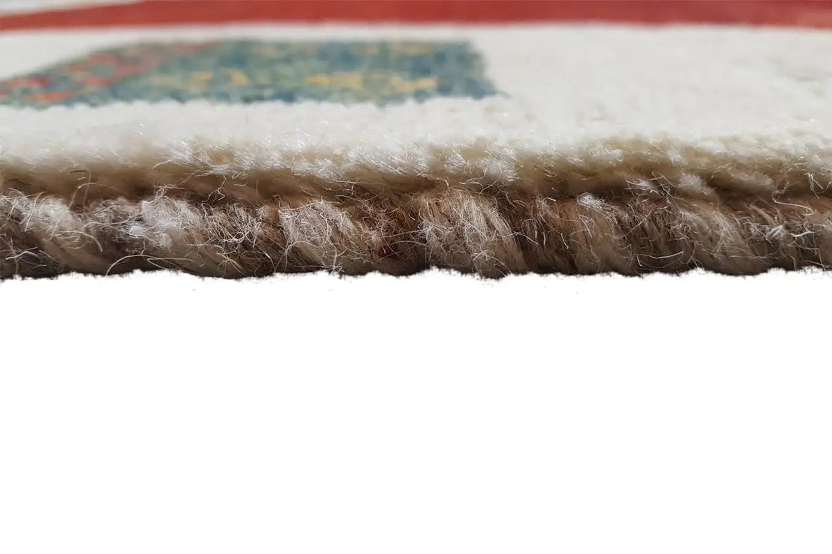Gabbeh rug: close-up of the rug edge with dense, brownish-red pile.