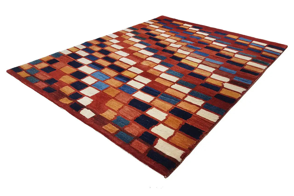 Gabbeh rug, diagonal view, geometric tile pattern in rust red, blue, and beige