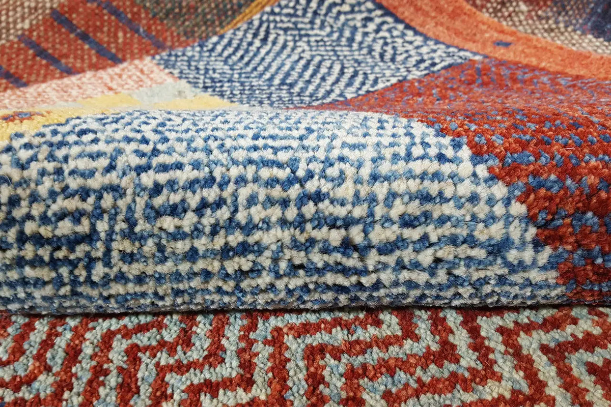 Gabbeh rug close-up: blue-white and orange patterns in the dense pile