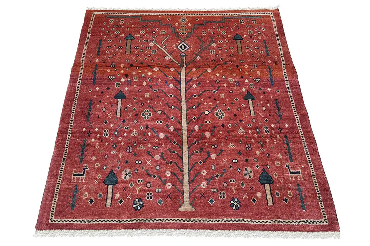 Reddish-brown Gabbeh rug with a medium-sized tree motif, surrounding border, and fringes