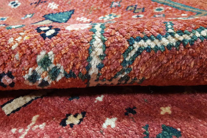 Close-up: reddish-brown carpet fabric with turquoise ornamentation and pile