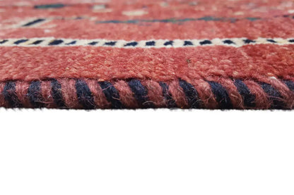 Detail of the carpet edge: reddish-brown pile with a multicolored border and fringes