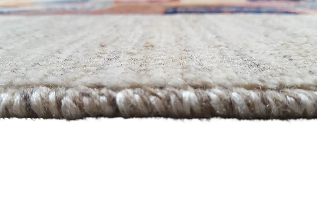 Close-up of the carpet edge with fringes and a light, dense pile