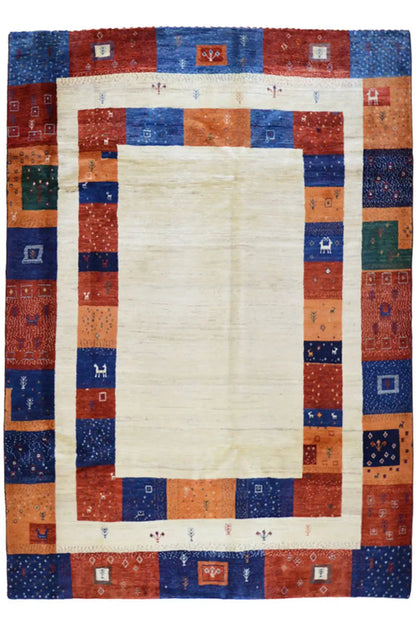 Gabbeh rug with a light center and a patchwork border in blue and red