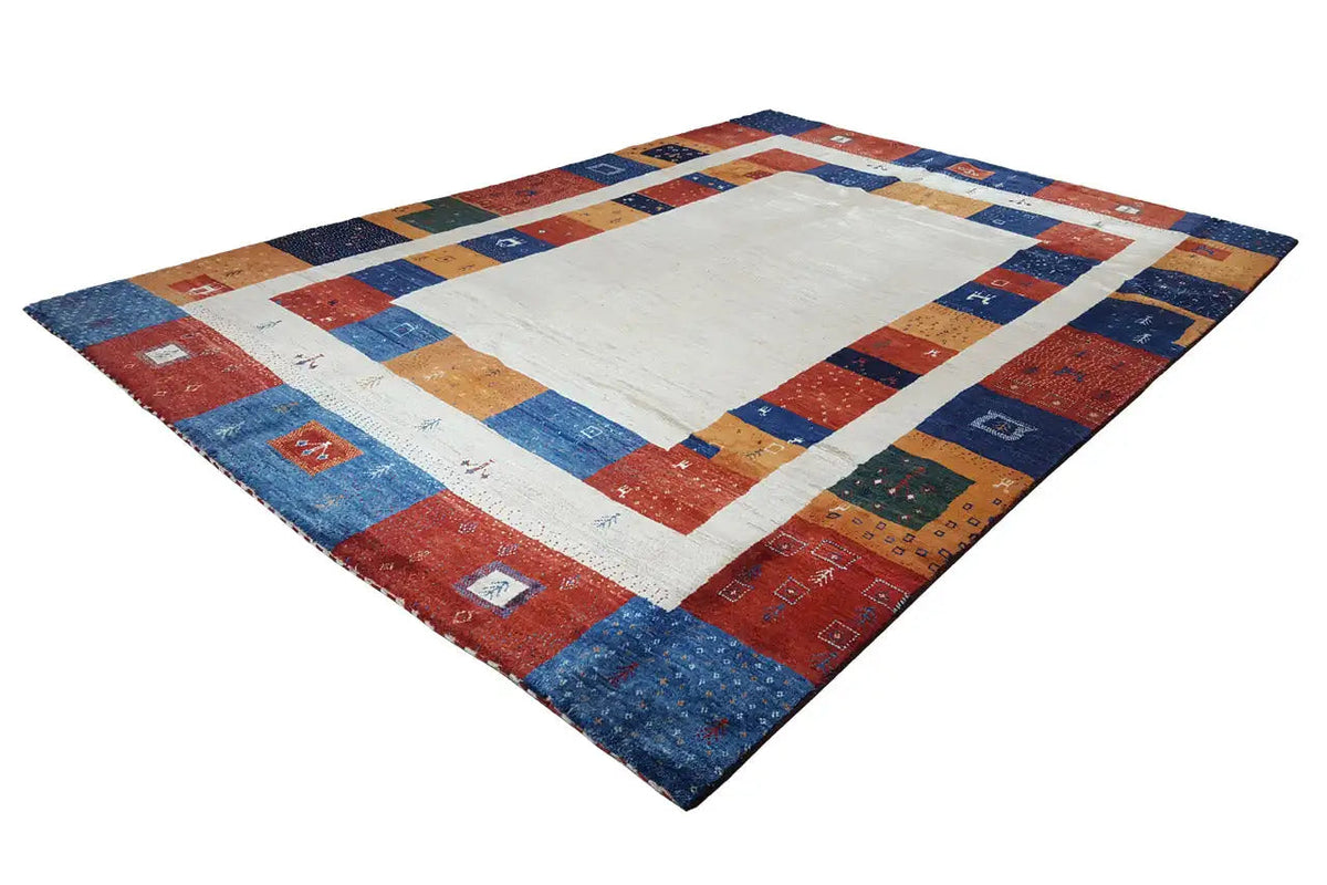 Gabbeh rug laid out: light patterned center with a multicolored block border