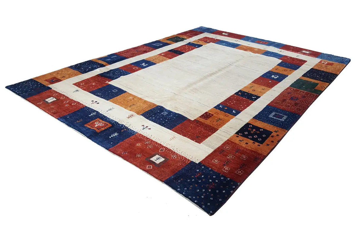 Gabbeh rug at an angle: light rectangle in the center, border with geometric block patterns in blue and red