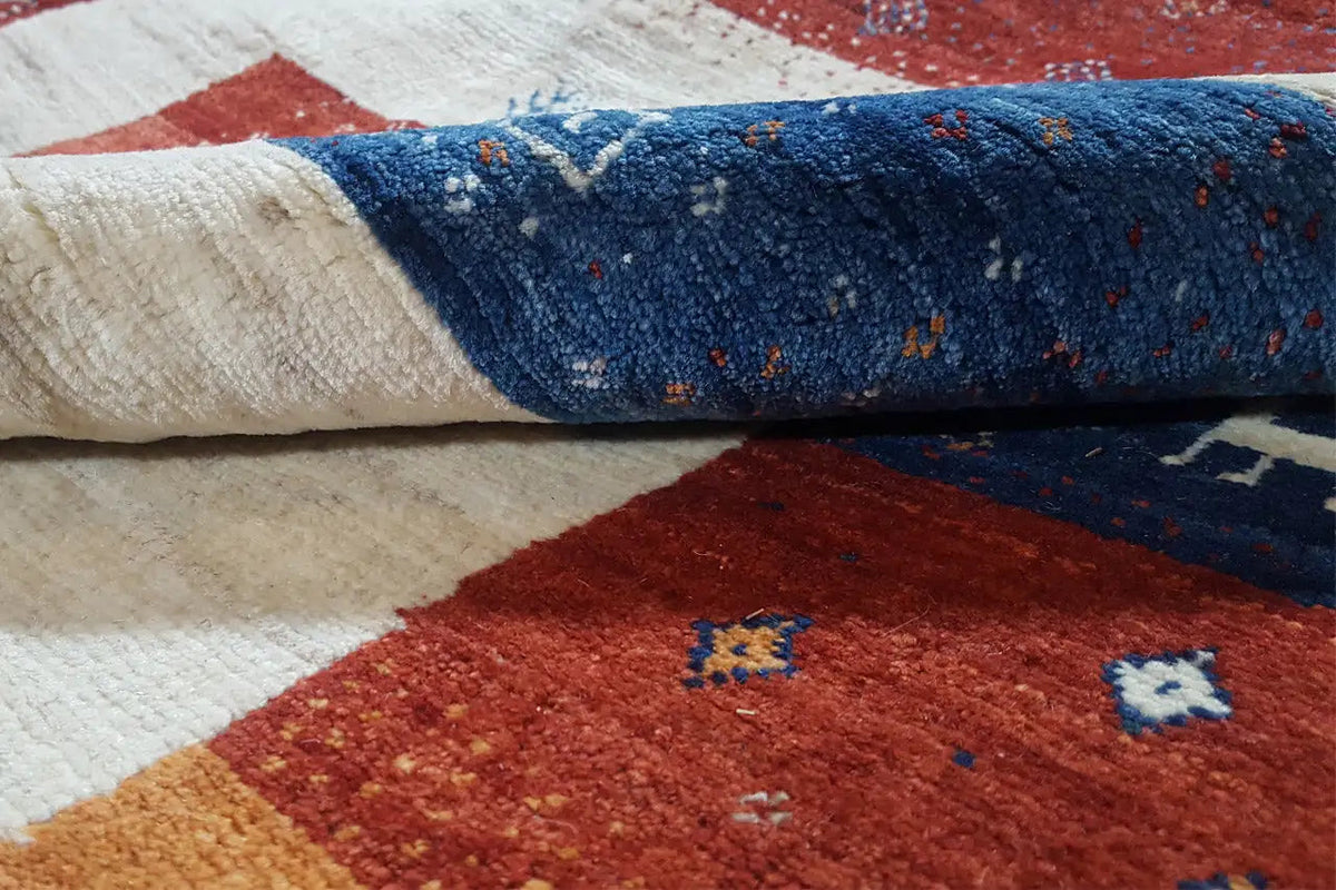 Gabbeh rug close-up: light texture with blue and red patchwork areas