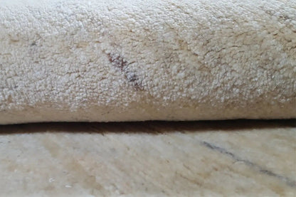 Close-up: beige carpet pile with a dense, short-pile texture and subtle shading.