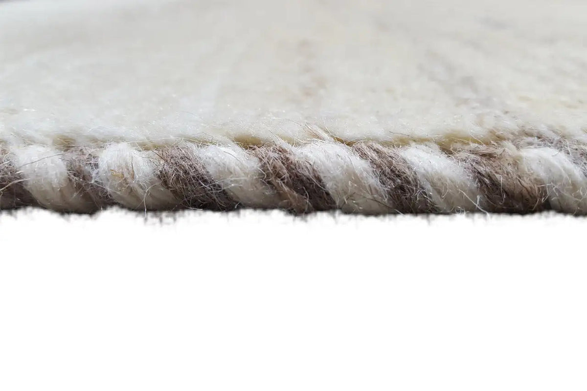 Rug edge with a short, dense pile and a slightly offset border area.