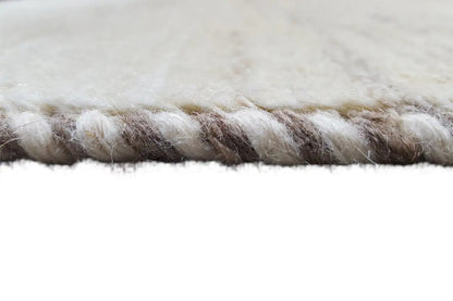 Rug edge with a short, dense pile and a slightly offset border area.
