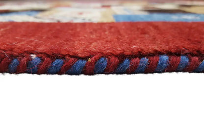Carpet edge with fringe: red yarn and blue-accented threads