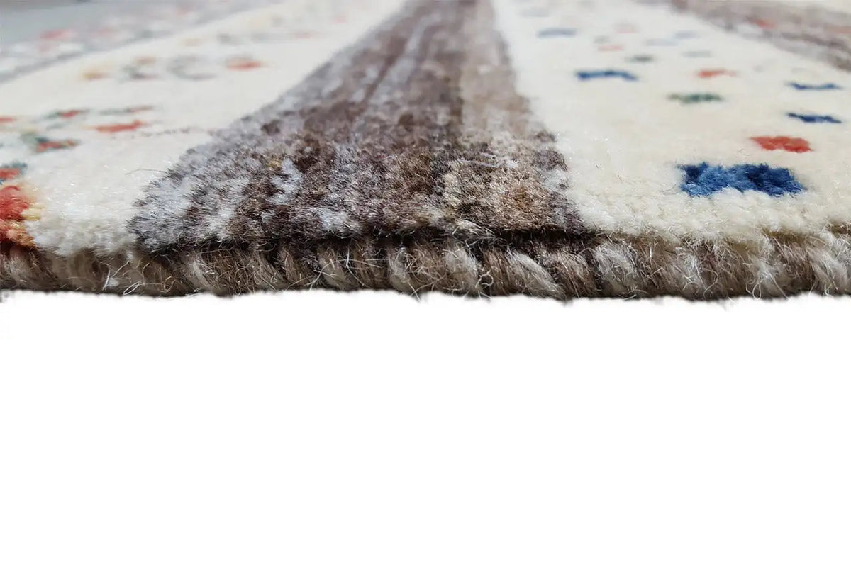 Gabbeh rug with a pile-textured border, light beige base, and multicolored patterns