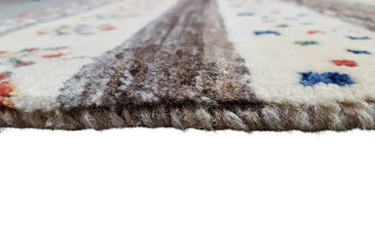 Gabbeh rug with a pile-textured border, light beige base, and multicolored patterns
