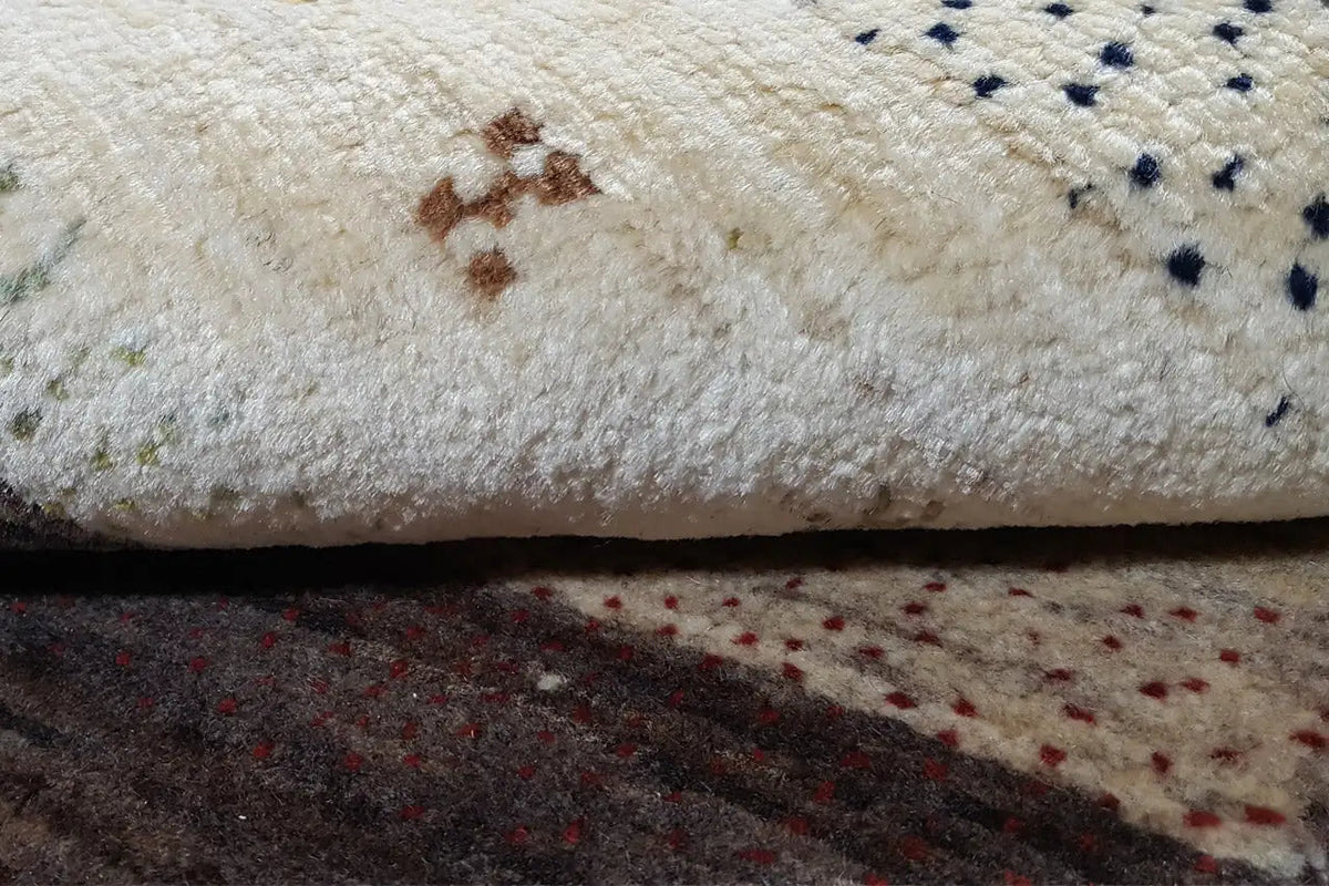 Gabbeh rug close-up: beige pile with colorful dots and motifs