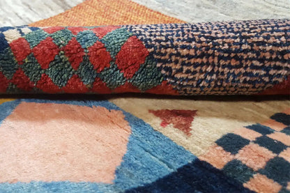 Gabbeh rug with a dense pile and patchwork motifs in red, blue, and beige