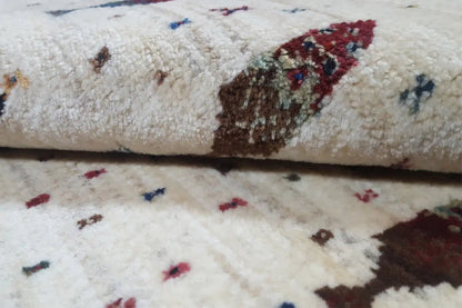 Gabbeh rug: pile detail with a colorful figurative motif on a light background