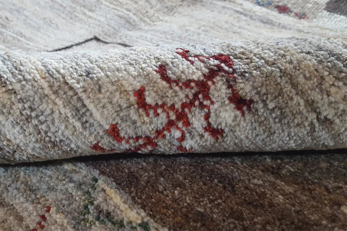 Gabbeh rug: close-up view with beige pile and red patchwork pattern