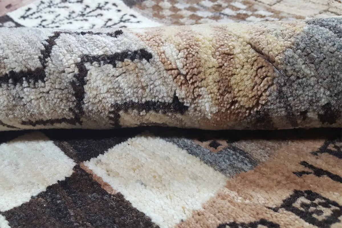 Gabbeh rug with a dense pile and patchwork details in beige, brown, and black