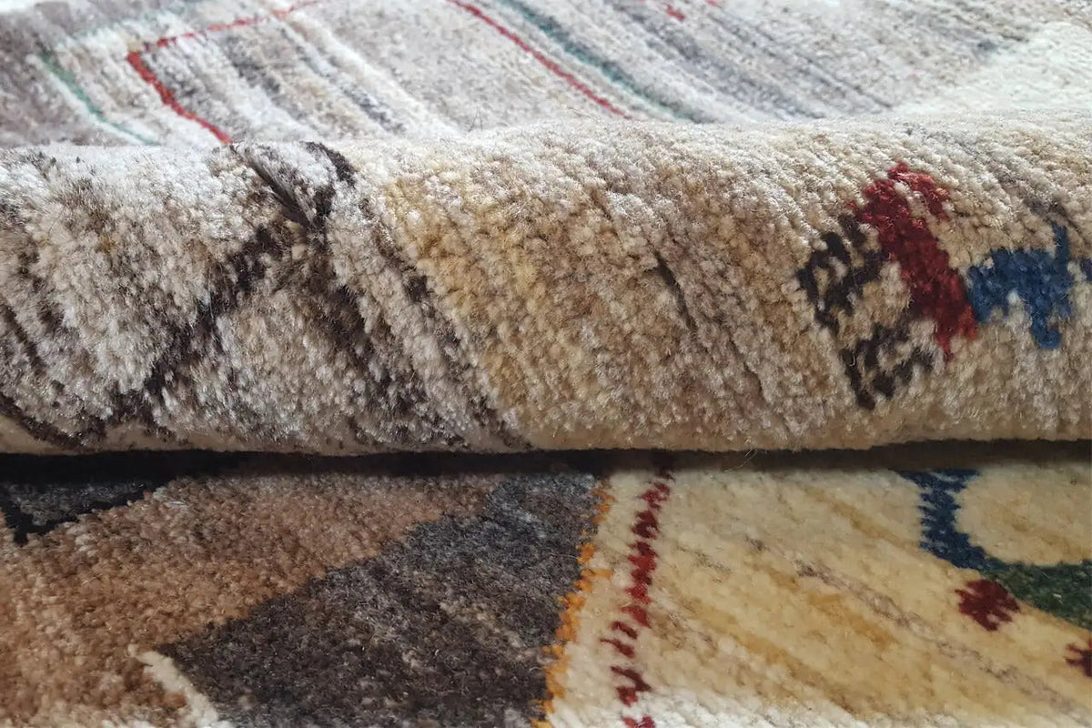 Close-up of the pile of the Gabbeh rug, mottled in beige, gray, and dark brown