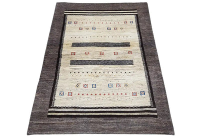 Gabbeh rug in front view with a cream-colored background, dark gray border and trim