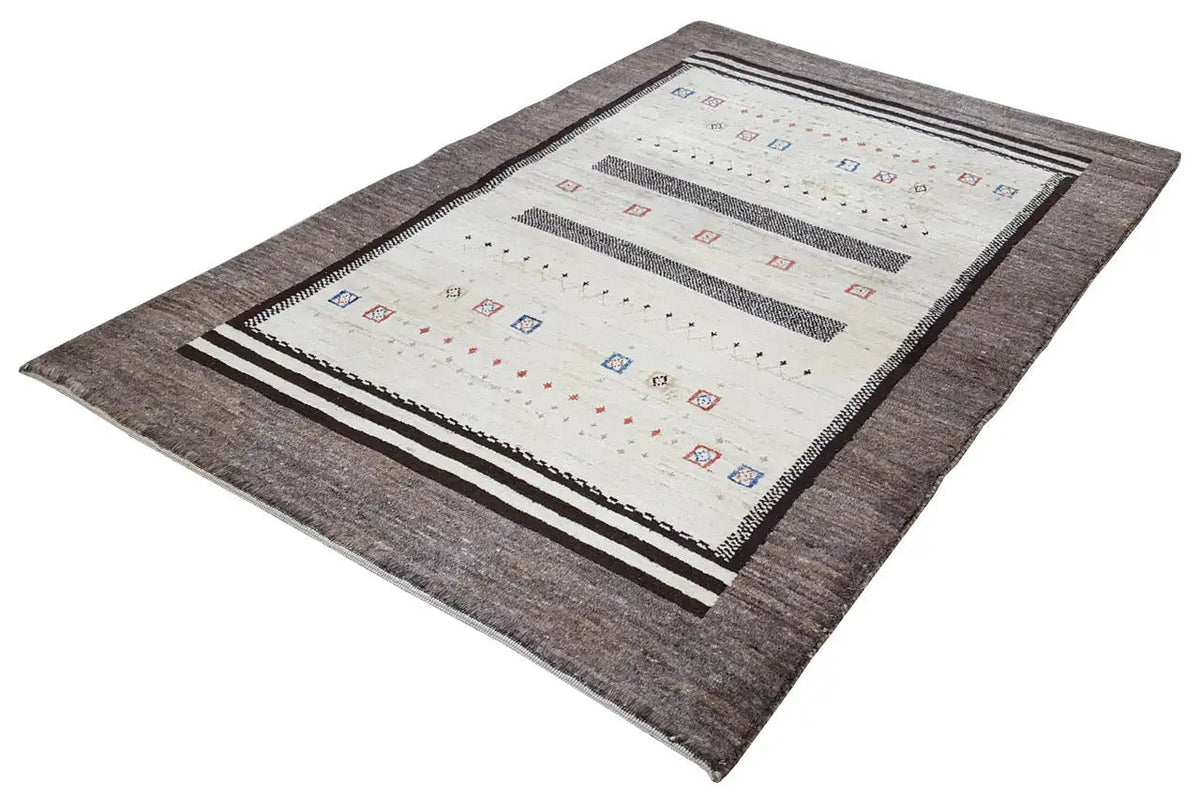 Gabbeh rug viewed from above at an angle: cream-colored field, dark gray border, stripes