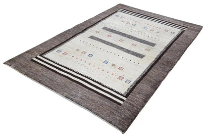 Gabbeh rug viewed from above at an angle: cream-colored field, dark gray border, stripes