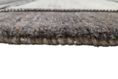 Close-up of a carpet edge: dense, dark brown pile with an even stitched edge