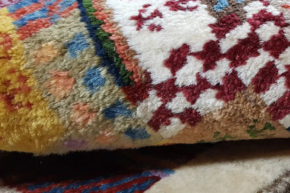 Close-up of the Gabbeh rug: pile with colorful motifs, red-and-blue detail
