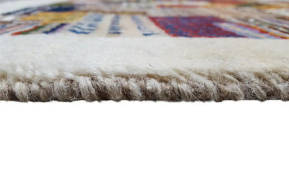 Gabbeh rug: fringes along the edge, dense beige pile with patterned area