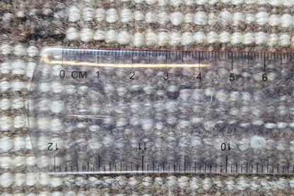 Gabbeh rug surface with measuring tape over the patterned pile