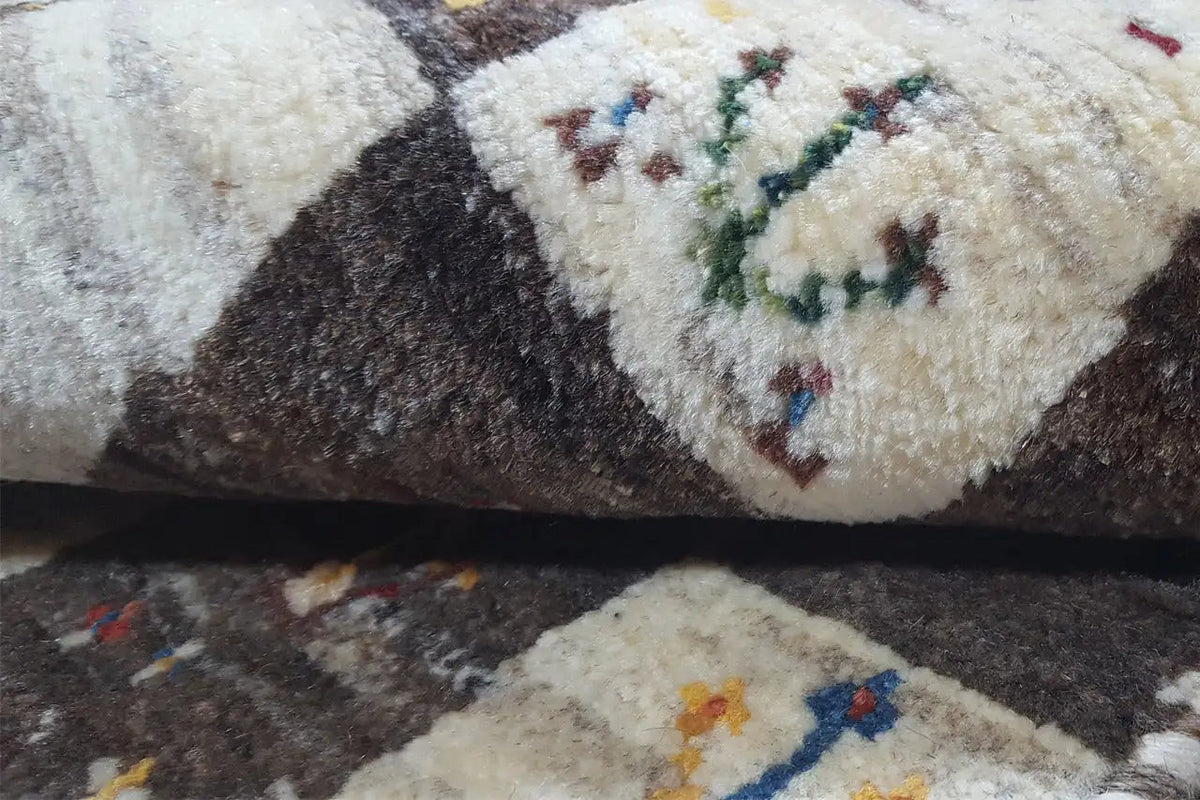 Gabbeh rug close-up: fluffy pile with colorful animal motifs in the pattern