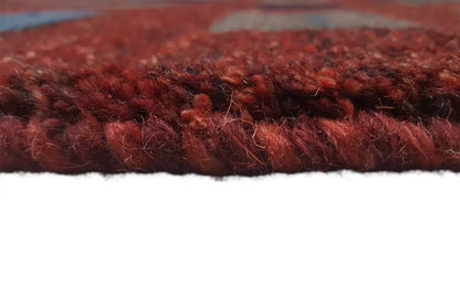 Gabbeh rug side view: dense reddish-brown pile with a cross edge