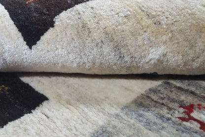 Gabbeh rug in detail: pile and cream-colored area with a dark pattern