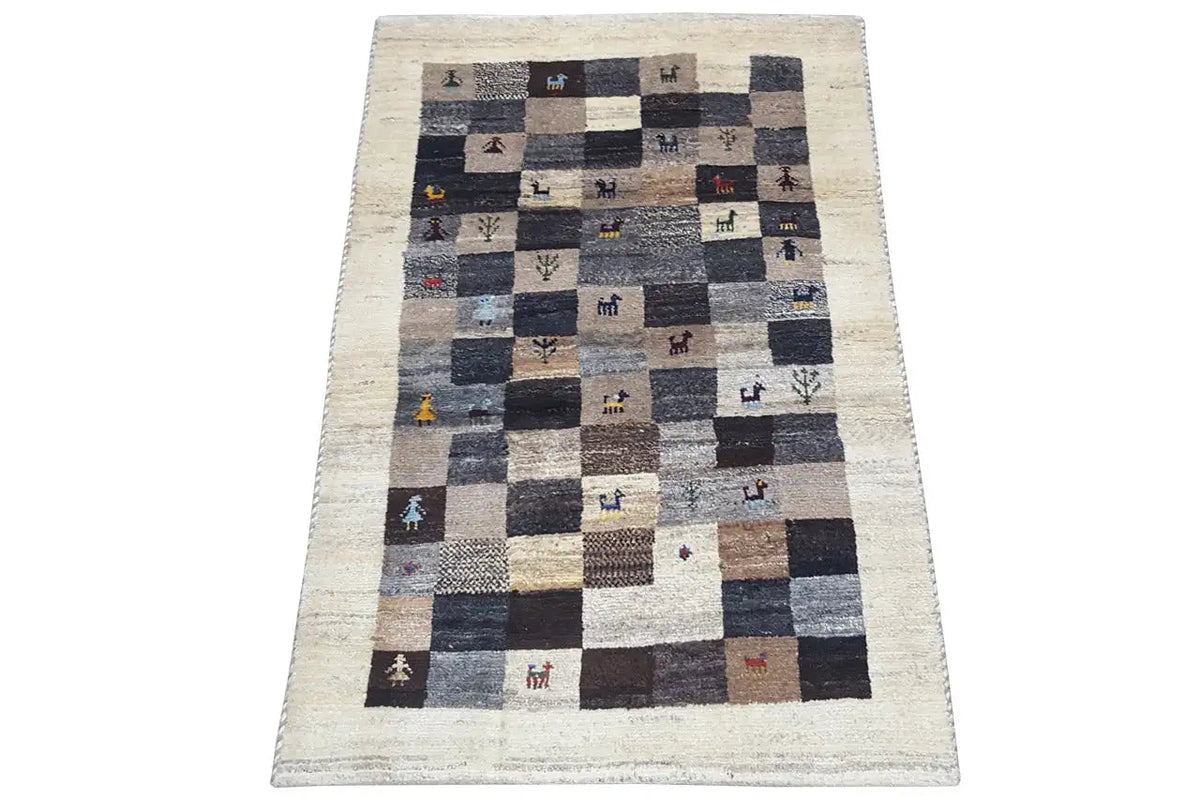 Gabbeh rug with patchwork check pattern, beige background, dark squares, small animal motifs