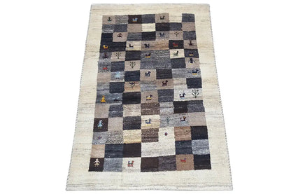 Gabbeh rug with patchwork check pattern, beige background, dark squares, small animal motifs