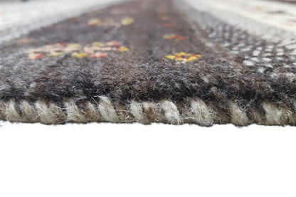 Carpet pile and edge seam in close-up, gray-brown material with a dense texture