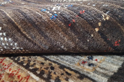 Close-up of a Gabbeh rug: dense pile with dark stripes and colorful accents