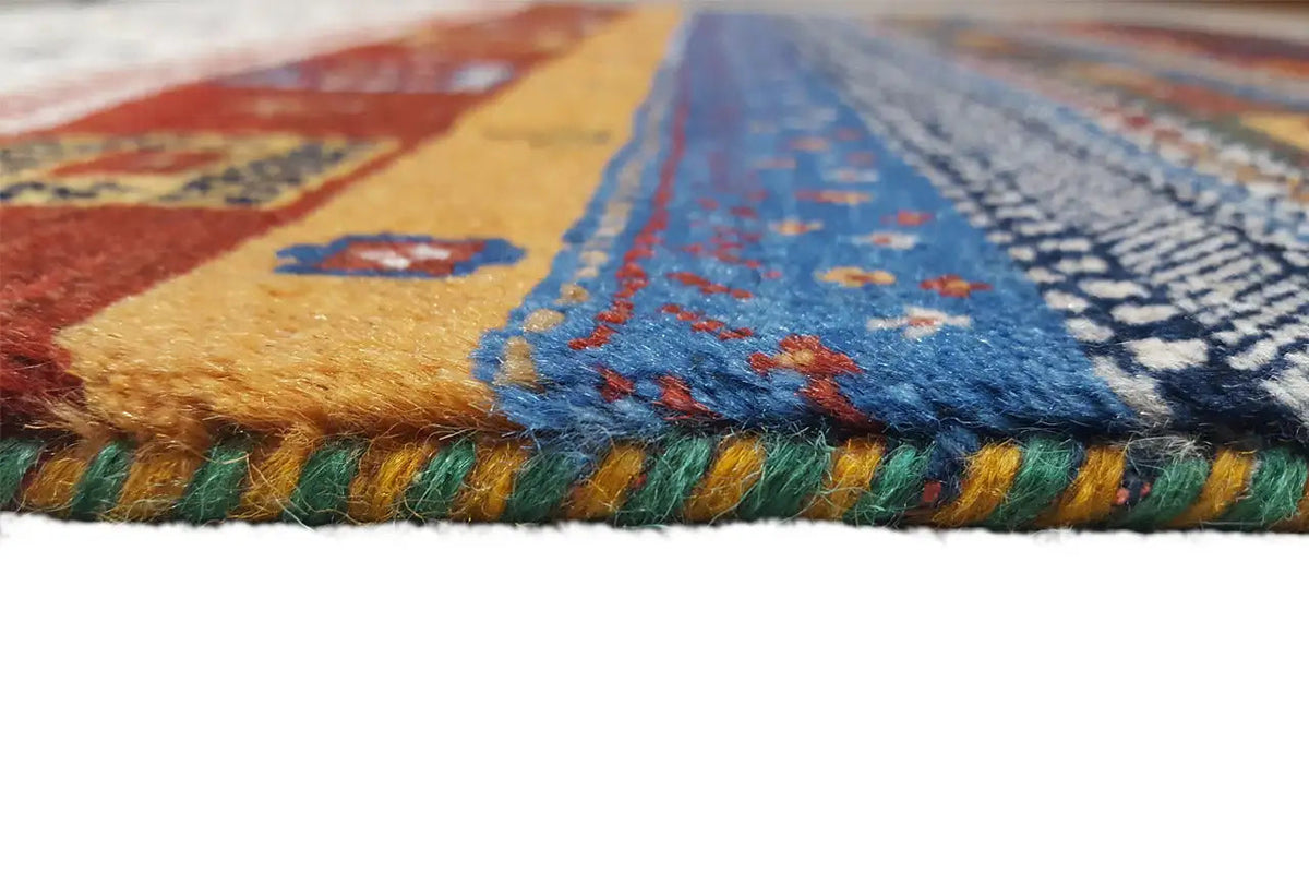Gabbeh rug close-up: multicolored pile and fringes along the edge