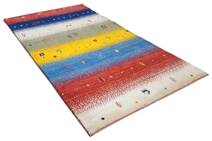 Gabbeh rug spread out with colored zones in red, blue, yellow, and beige.