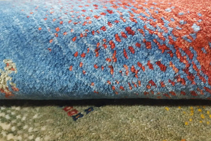 Close-up: Gabbeh rug with a blue-red pattern and fine colorful details.