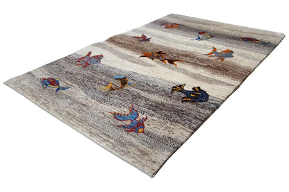 Rug lying at an angle with colorful animal motifs, light gray background and dark stripes
