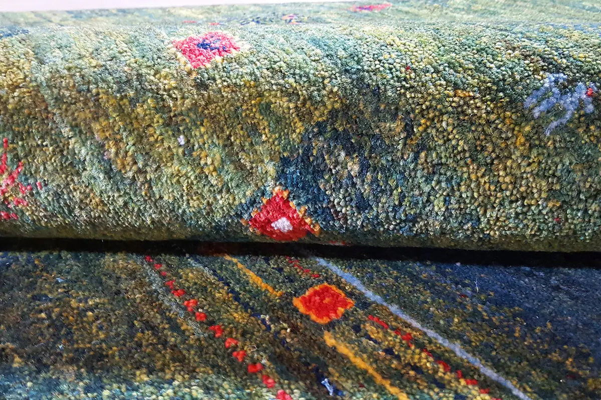 Gabbeh Lori rug close-up: dense pile in green with red and blue color accents