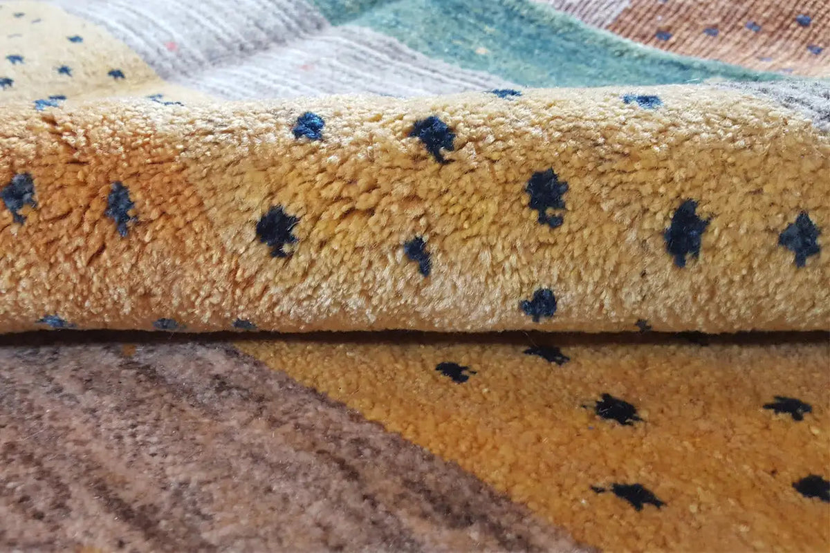 Close-up of a Gabbeh rug: fine pile texture and dark blue patterned dots