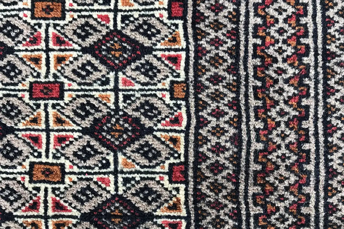Close-up of a Turkmen poshti: geometric ornamental pattern in dark, red, and beige