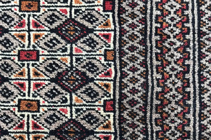 Close-up of a Turkmen poshti: geometric ornamental pattern in dark, red, and beige