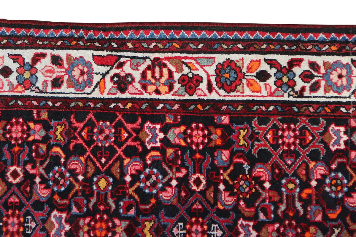 Close-up of the border: dark red pattern with stylized flowers and diamonds